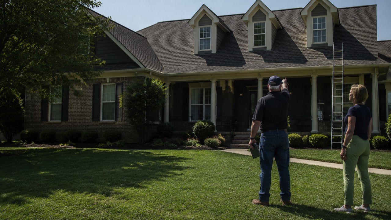 Roofing salesperson reviewing a roof with a homeowner before an inspection